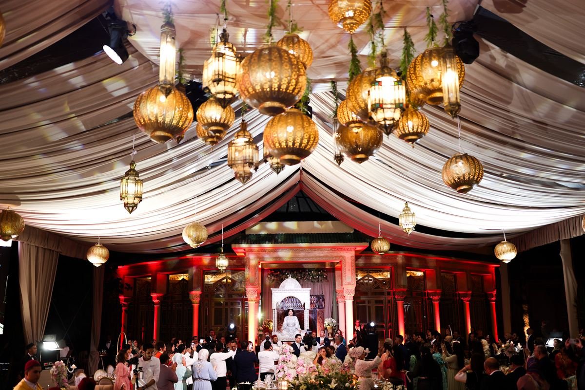 Salle de réception marocaine illuminée de lanternes dorées